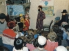 Purimshpiel-children's opera in the Itzhak Kogan’s apartment. In the background: to the left at a piano – Michael Makushkin (Ezer);  in the center – Daniel Romanovsky; to the right in a corner - Itzhak Kogan. Leningrad, 1986. co RS